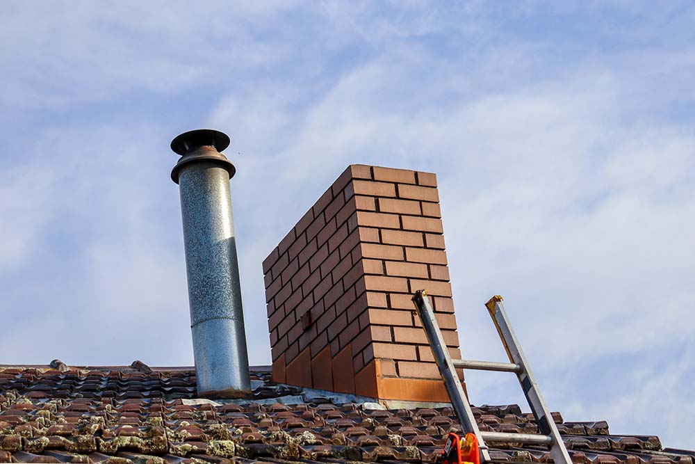 low-angle-view-chimney-ladder-roof-against-sky